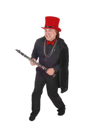 A indigenous man in a black shirt and pants and red hat fighting with
his clarinet in his hand, isolated for white backgroundの写真素材