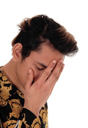 A young sad looking man standing in profile with his hand over his face
is in distress, close up, isolated for white backgroundの写真素材