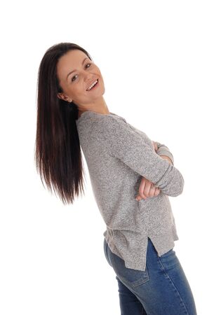 A lovely smiling young woman standing in the studio bending backwards
with her long brunette hair, isolated for white backgroundの写真素材