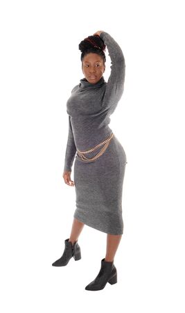 A beautiful young African American female standing in a tight
gray dress, with one hand on her head, isolated for white backgroundの写真素材