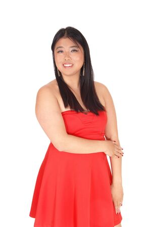 A beautiful young Chinese woman standing from front is a red dress
and long black hair, isolated for white backgroundの写真素材
