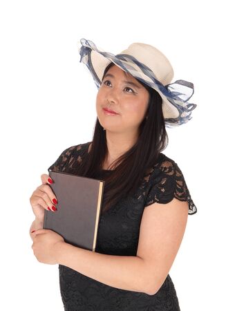 A gorgeous young Chinese woman standing in a black dress
and long black hair wearing a summer hat, isolated for white backgroundの写真素材