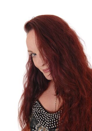 A close up image of the face of a pretty woman looking into the camera
with her blue eyes and long red hairの写真素材