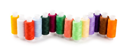 Spools multi-colored threads located a wave isolated on a white background