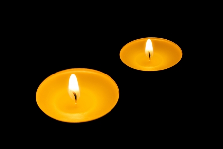 Two burning candles on a black backgroundの写真素材