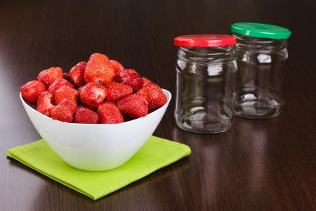 Strawberry cleared in a white bowl and empty jars with covers for house conservationの写真素材