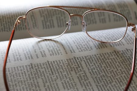 Glasses on an English dictionaryの写真素材