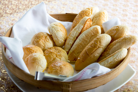 Bread buns on white cloth in a basket