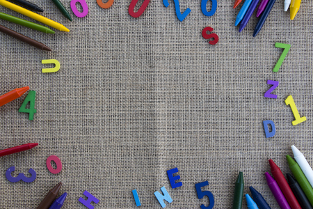 Creative sack texture background surrounded by colorful crayons, numbers and alphabetsの写真素材
