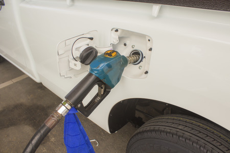 Holding fuel nozzle and refuel car in gas stationの写真素材
