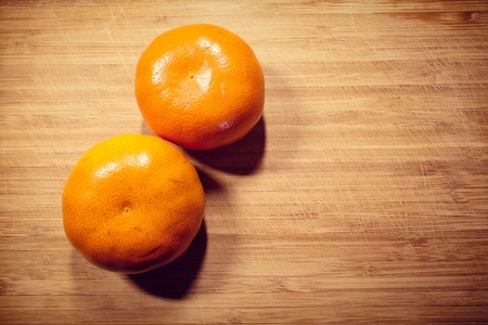 Two fresh tangerine not peeled on a wooden board. Vitamin Cの写真素材