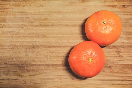 Two fresh tangerine not peeled on a wooden board. Vitamin Cの写真素材