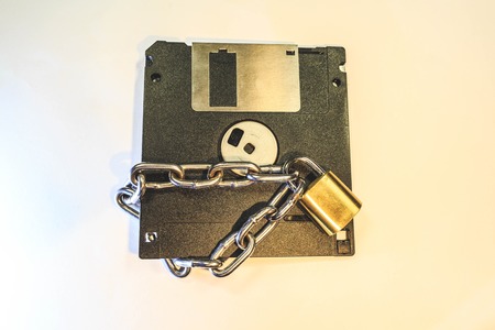 The diskette is protected by a golden lock with a chain.の写真素材