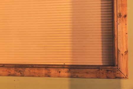 White blinds close the large window. Evening lights.の写真素材