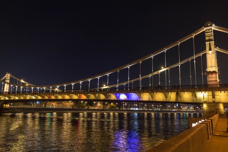 The long beautiful bridge across the river in the evening in the night lights.の写真素材