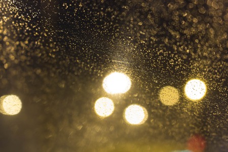 Glass with raindrops and lights out of focus. Abstraction, autumn.の写真素材