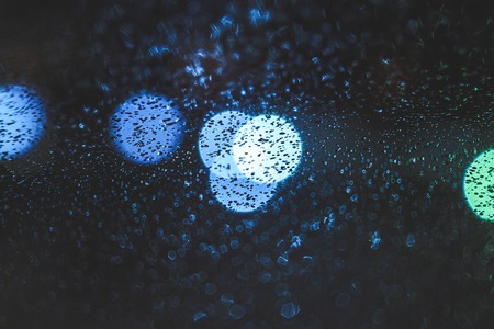 Glass with raindrops and lights out of focus. Abstraction, autumn.の写真素材