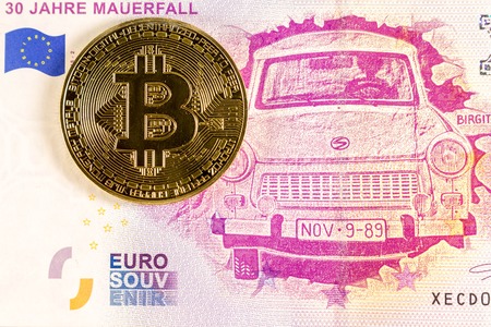 Bitcoin coin on the 0 euro bill lies