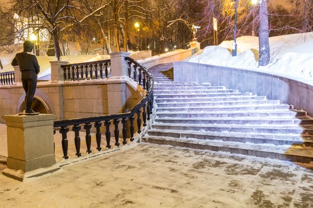 Staircase in the winter garden covered with snow. Evening time with lanterns.の写真素材