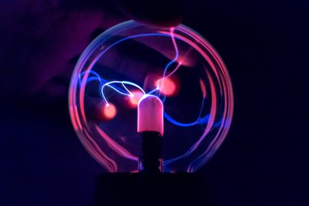 Attraction of charge to the fingers on a ball of a tesla coilの写真素材