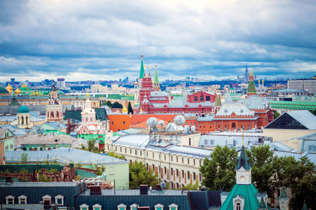 Roofs of colorful houses in the center of Moscow. In the distance Red Square against the sky with...