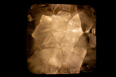 Abstract macro view of translucent mineral crystal formations on black background