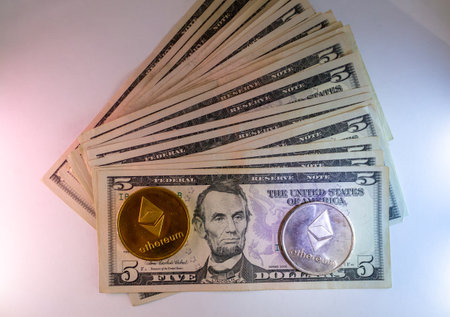 Golden ethereum coin and dollar banknotes on a white background.