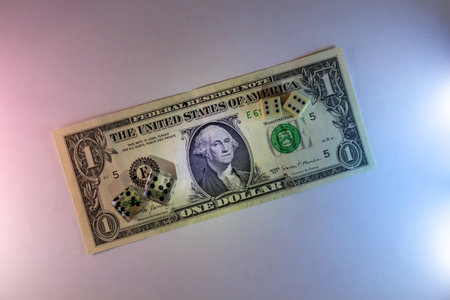 A single us dollar bill with casino chips on a dark background