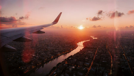 Stunning aerial view of a cityscape at sunset from airplane windowの素材