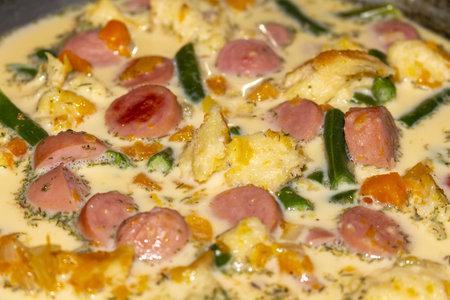 A delicious homemade creamy sausage with fresh dill and colorful vegetablesの写真素材