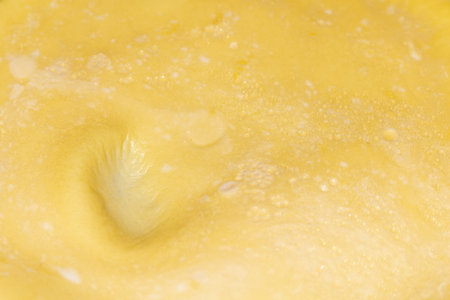 A close up detailed texture of golden surface with small bubbles and natural patterns