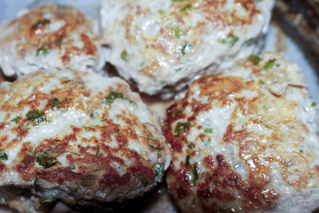 Appetizing homemade fried chicken patties with fresh herbs on a tray for dinner
