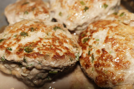 Fried chicken cutlets with fresh herbs on a pan for dinner