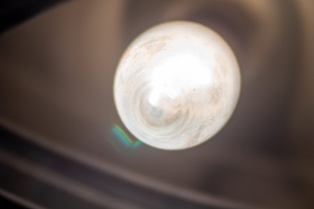 Warm glowing lightbulb hanging from the ceiling in a dark room interior illumination