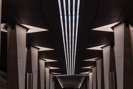 A modern interior hallway with geometric lighting fixtures and sleek column design