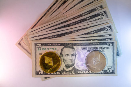 Ethereum Cryptocurrency And Five Us Dollar Bills Stacked Together On White Background