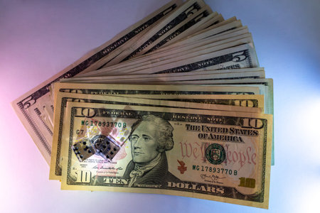A stack of american ten dollar bills and five dollar notes in a fan arrangement