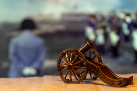 Historical miniature cannon with blurred figures in background for remembrance day