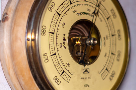 Antique barometer instrument measuring atmospheric pressure weather forecasting device in wooden...
