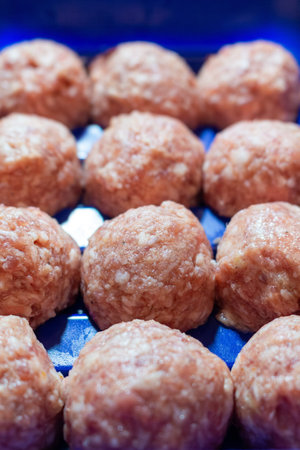 Raw meatballs in blue tray ready for cooking delicious food preparation
