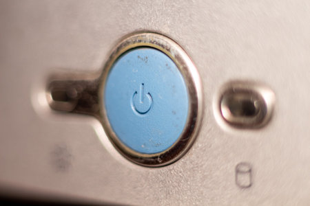Power button on digital camera device silver metallic surface macro detail