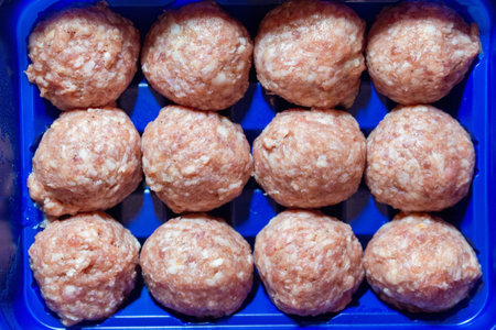 Raw meatballs in plastic container ready for cooking top view arrangementの写真素材