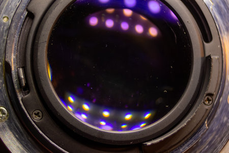 A detailed view inside a professional digital camera lens mount with colorful bokeh lights