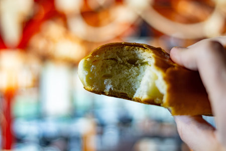 A delicious freshly baked bread loaf in hand with blurred bakery background for commercial use