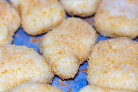 A delicious arrangement of golden fried fish nuggets on blue paper surface