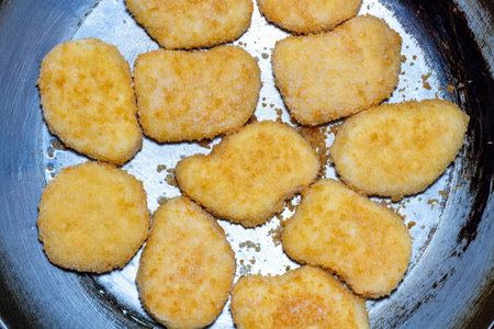Golden crispy chicken nuggets in frying pan delicious fast food meal concept
