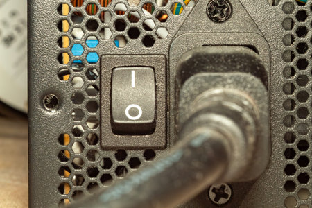 Power supply unit connectivity detail with cable and switch on metal surface