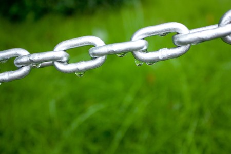 Closeup chain above green grass.の写真素材
