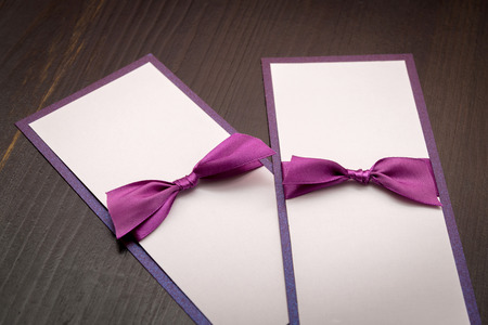 two handmade cards with purple satin tape on wood background