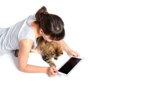 young woman and cat using tablet computer on white backgroundの写真素材